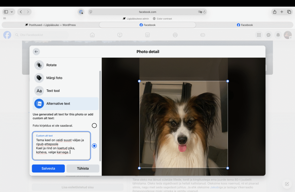 Foto facebooki postituse loomise vaatest, kus postitusele on lisatud koera pilt. Vasakul on menüü , valikutega nagu 'Rotate', 'Märgi foto' 'Text tool', and 'Alternative text', mis on valitud. Valikute all on kiri, "Use generated alt text for this photo or add custom alt text: Foto kirjeldus ei ole saadaval." kastis kirjaga custom alt text on tekst:: "Tema keel on veidi suust väljas ja ripub ettepoole. Kael ja rind on kaetud pika, koheva, valge karvaga.". kasti all on kaks nuppu: 'Salvesta' ja 'Tühista'